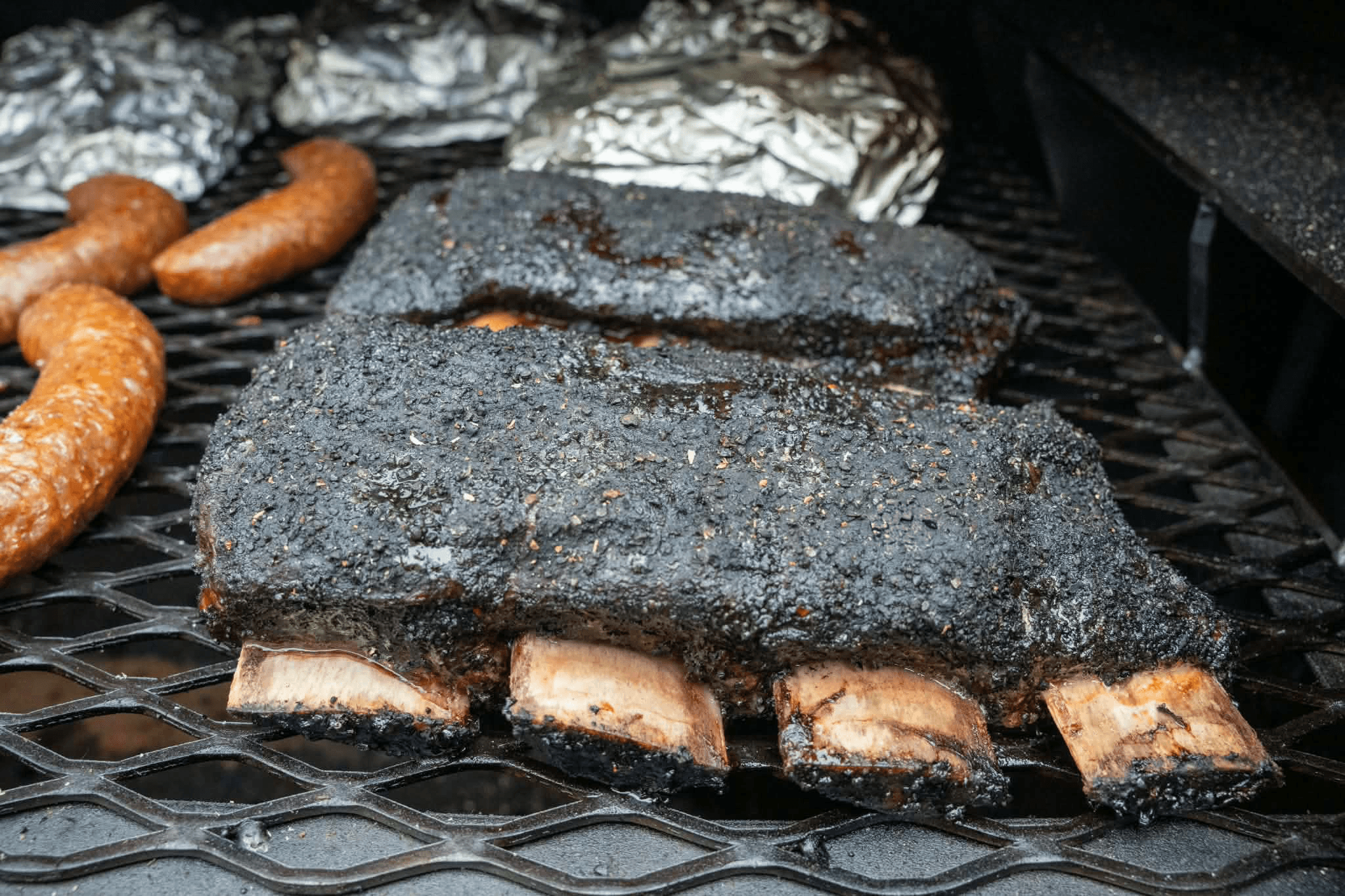 Bark-crusted smoked ribs and sausages fresh off the smoker